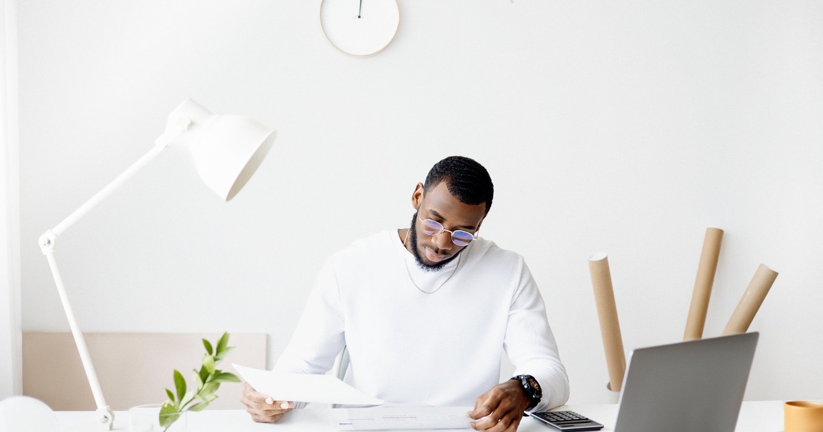 Writer looking at sales copy while sitting at a desk with laptop